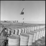 RAAF helicopter flying low near drums of BP fuel