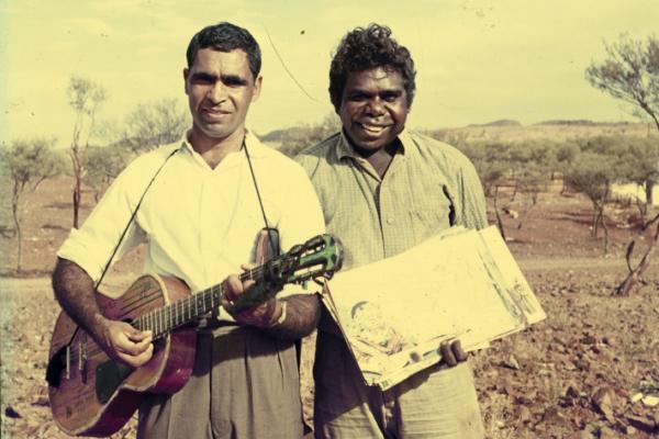 Ron Williams holding a guitar with another Aboriginal man