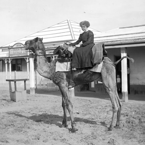 Riding a camel in front of the Union Bank Port Hedland ca 1910