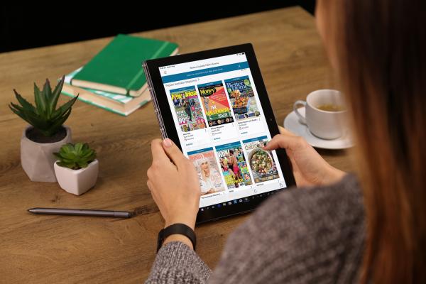 Woman selecting magazines from OverDrive on a tablet screen