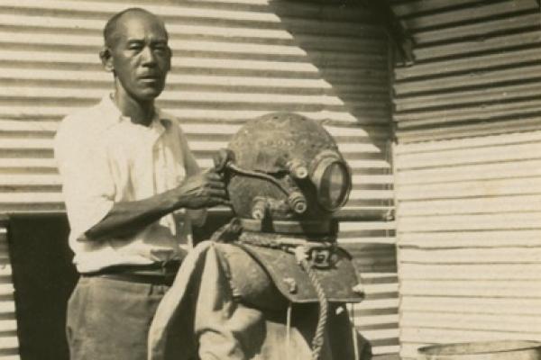 Japanese man with an old diving suit propped up on a chair