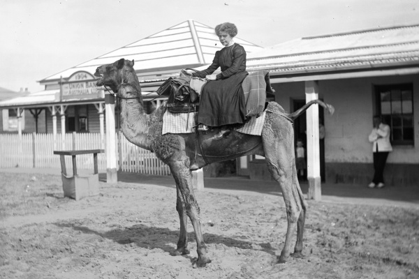 Riding a camel in front of the Union Bank Port Hedland ca 1910