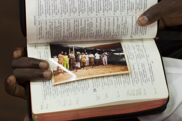 Holding a picture of choir members in the refugee camp of Tanzania where members spent up to 12 years before relocating to Australia 