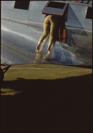Faye James demonstrating an emergency exit from a DC3 at Perth Airport November 1961